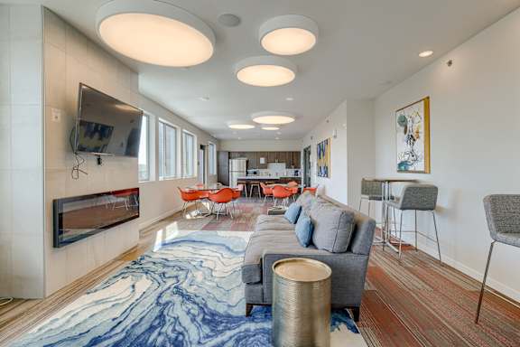 A living room with a grey couch and a blue and white rug.
