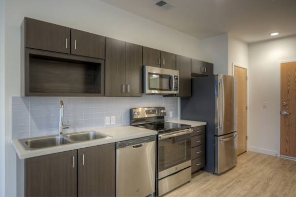 A modern kitchen with stainless steel appliances and wooden cabinets.