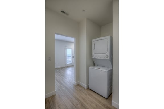 A white microwave oven is on a counter in a room.