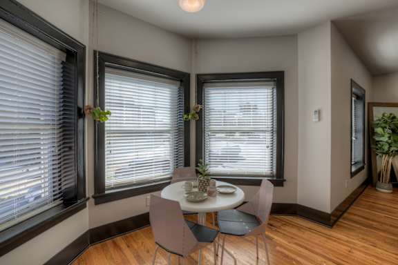 A dining room with a table and chairs.