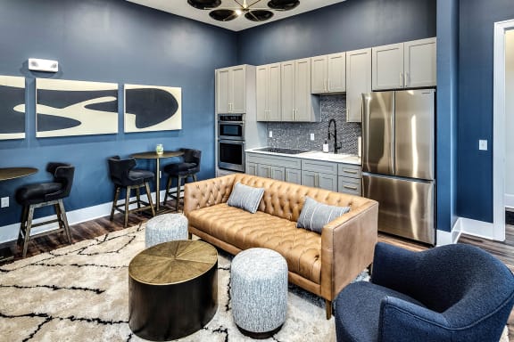 a living room with blue walls and a kitchen with stainless steel appliances