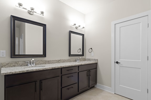 a bathroom with two sinks and two mirrors