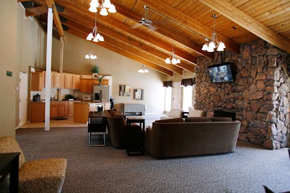 A living room with a stone fireplace and a television.