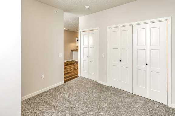 A room with white doors and a carpeted floor.