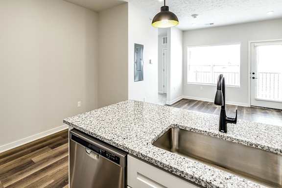 A kitchen with a granite countertop and stainless steel appliances.