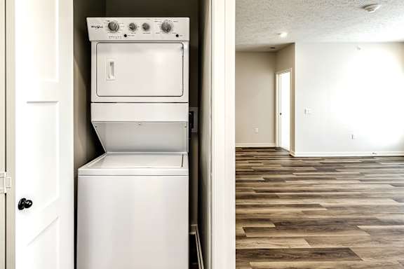 A white oven and dishwasher are in a kitchen with wood flooring.