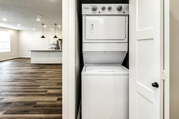 A white oven with a door open is in a kitchen.