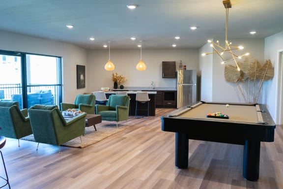 a game room with a pool table and chairs
