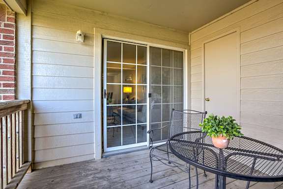 A balcony with a table and chairs and a potted plant.