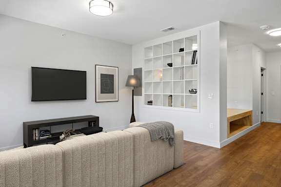 A living room with a couch, a television, and a bookshelf.