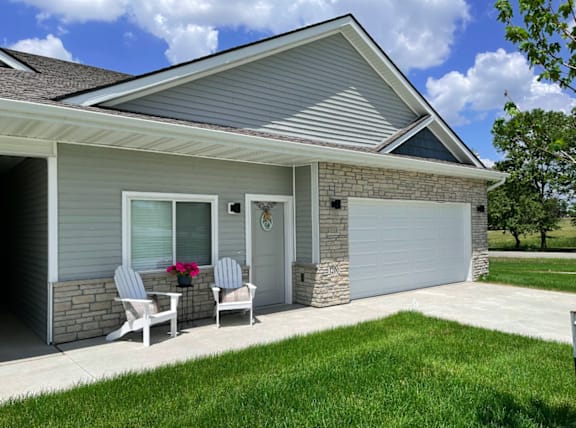 A house with a grey roof and a white garage door.