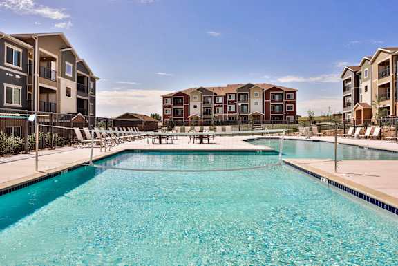 A swimming pool in front of apartment buildings.