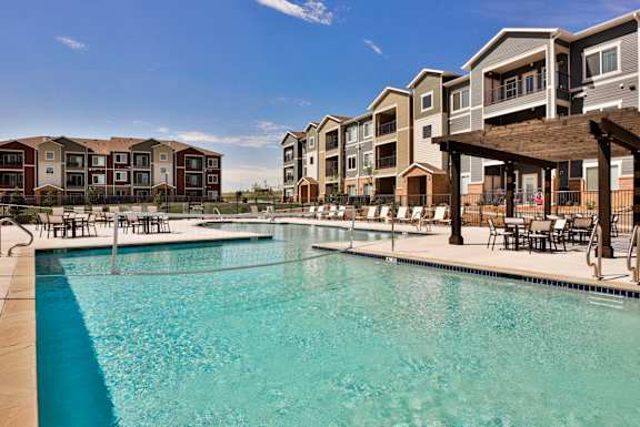 A swimming pool in front of apartment buildings.