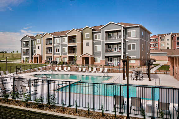 A large apartment complex with a pool in the foreground.