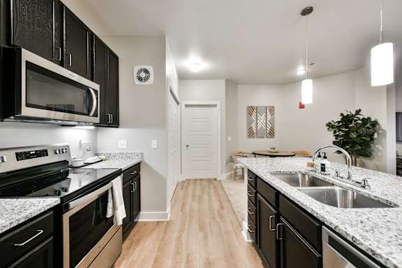 A kitchen with black cabinets and granite countertops.