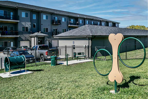 A dog park with a large dog sculpture in the foreground.