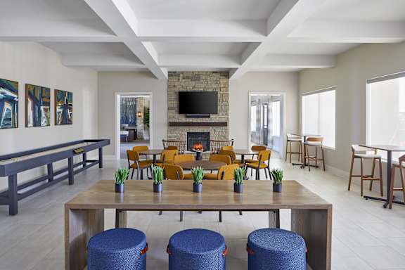 A modern living room with a fireplace and a long wooden table.