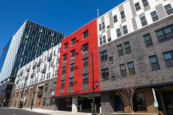 A modern building with a glass entrance and a sign that reads at Center Square Lofts West, Allentown, 18101