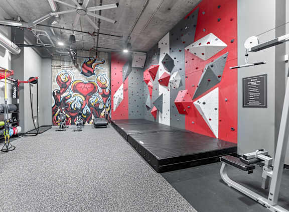 A gym with a red wall and a black mat at Cityplace Apartment Homes Apartments, Allentown, PA, 18101