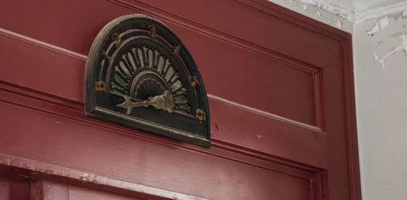 A clock mounted on a red door. at The Lady, South Carolina