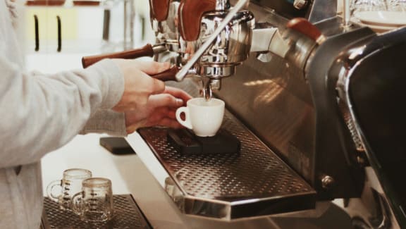 A person is making a cup of coffee using a coffee machine. at The Lady, South Carolina
