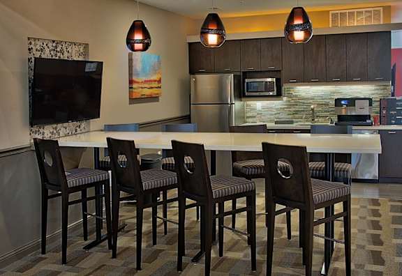 A kitchen with a table and chairs.
