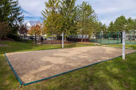 Sand volleyball court with net and poles at Village Club of Farmington Hills Apartments, Michigan, 48331