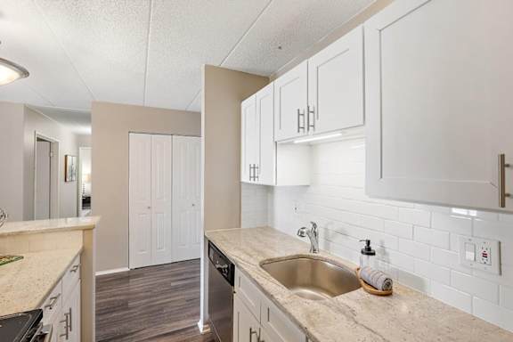 A kitchen with a sink, stove, and cabinets.