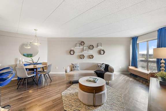 A living room with a blue chair and a white couch.