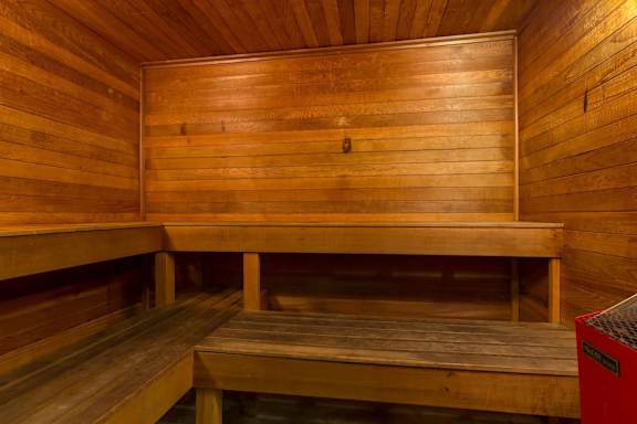 Wooden sauna with tiered bench seating and heater at Village Club of Farmington Hills Apartments, Farmington Hills, MI 48331