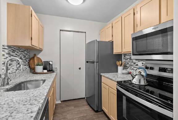 A kitchen with a sink, refrigerator, and stove.