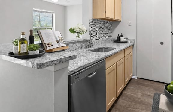 A kitchen with a marble countertop and a stone backsplash.