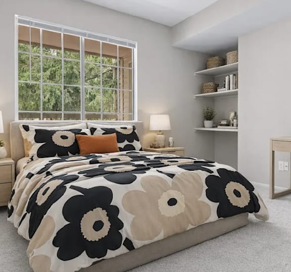 A bed with a black and white floral comforter is in a room with a window.