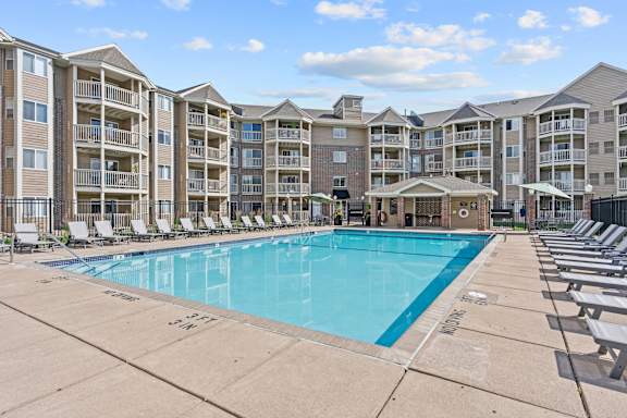 A large swimming pool in front of apartment buildings.