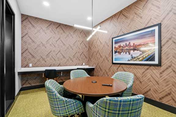 Conference Room and WFH space with chairs, a table, TV, and charging ports at The Cosmopolitan, Minnesota, 55101