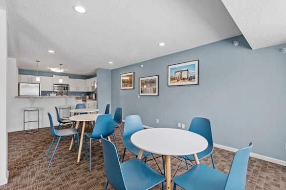 A dining area with a white table and blue chairs.