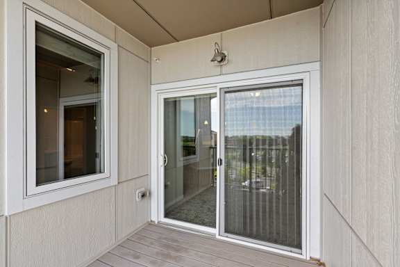 A balcony with a glass door and a window.