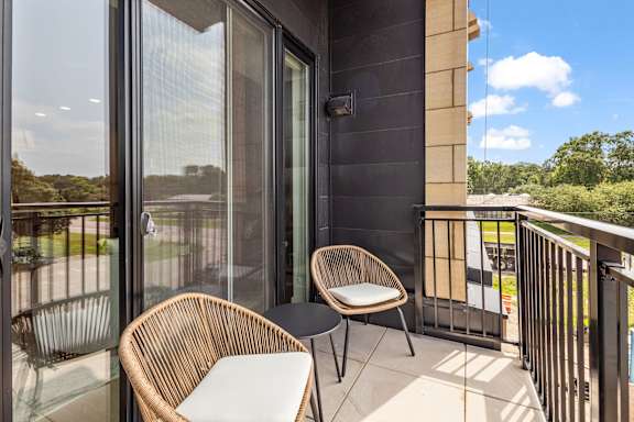 A balcony with a chair and a table.