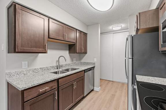 A kitchen with brown cabinets and a granite countertop.