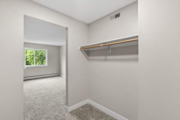 A room with a window and a shelf.