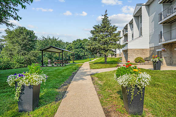 A sunny day at a residential area with a walking path and flower pots.