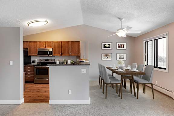 A kitchen with a dining table and chairs.