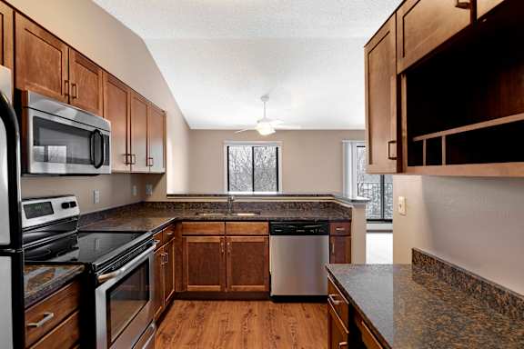 A kitchen with wooden cabinets and stainless steel appliances.