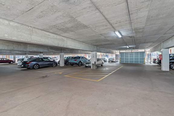 A parking garage with several cars parked.