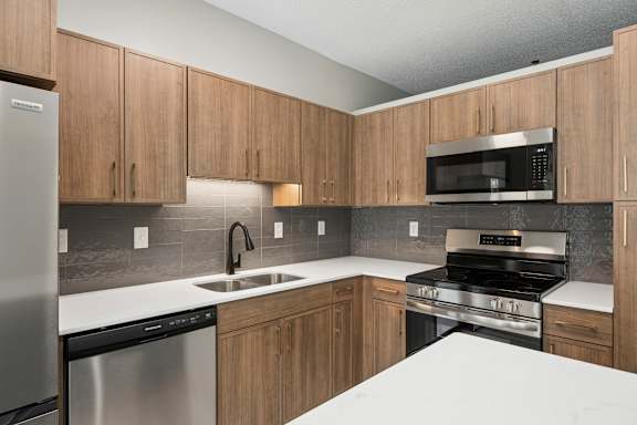 A kitchen with wooden cabinets and stainless steel appliances.