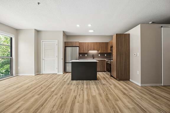 A modern kitchen with wooden floors and white walls.