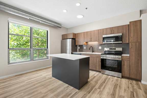 A modern kitchen with wooden cabinets and a large island.