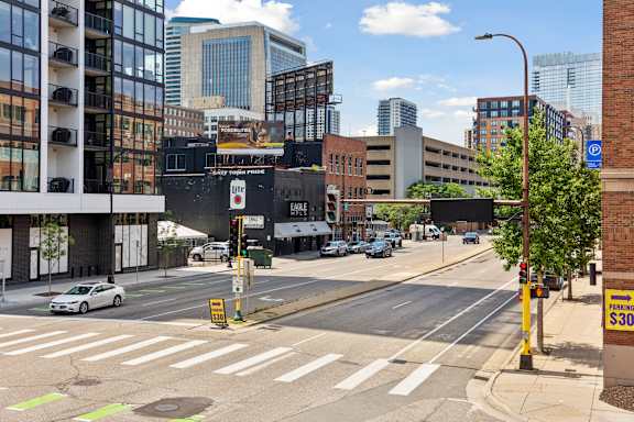 A city street with a white car driving on the road.
