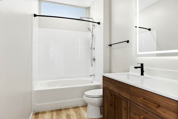 A white bathroom with a toilet, sink, and bathtub.