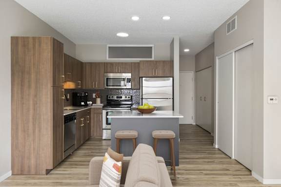 A modern kitchen with a bar stool and a couch.